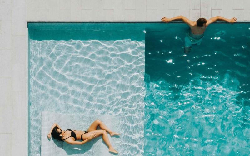 a couple of people swimming in a pool