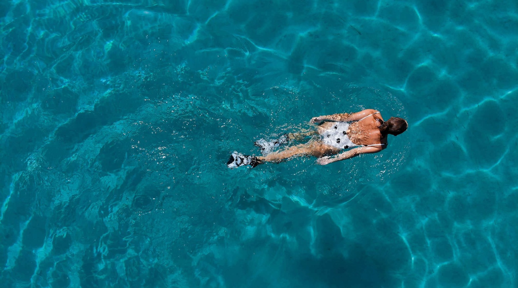 Sparkling swimming pool aerial view of a person swimming in a large pool