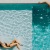 a couple of people swimming in a pool