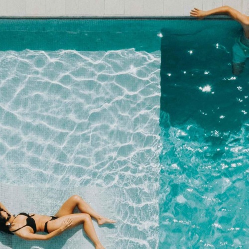Resort-style swimming pool a couple of people swimming in a pool